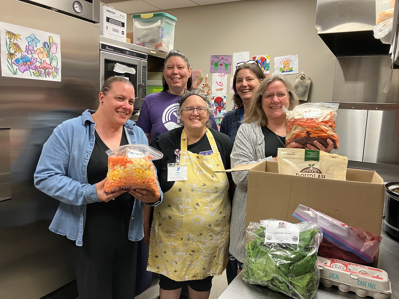 Adults in kitchen with donated veggies